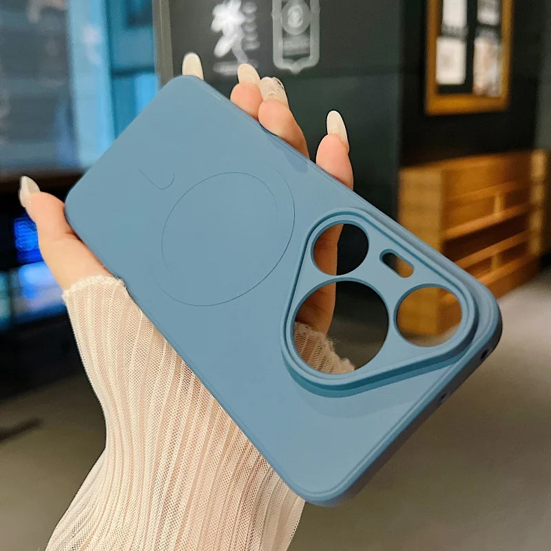 A light blue silicone phone case with a magnetic ring and camera cutouts is held in a hand.