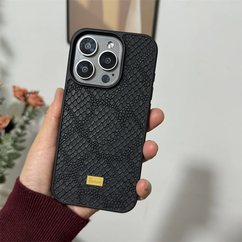 Black snakeskin pattern phone case with a gold "Harrods" label.