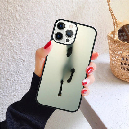 A hand holds an iPhone with a reflective case featuring a running horse design.